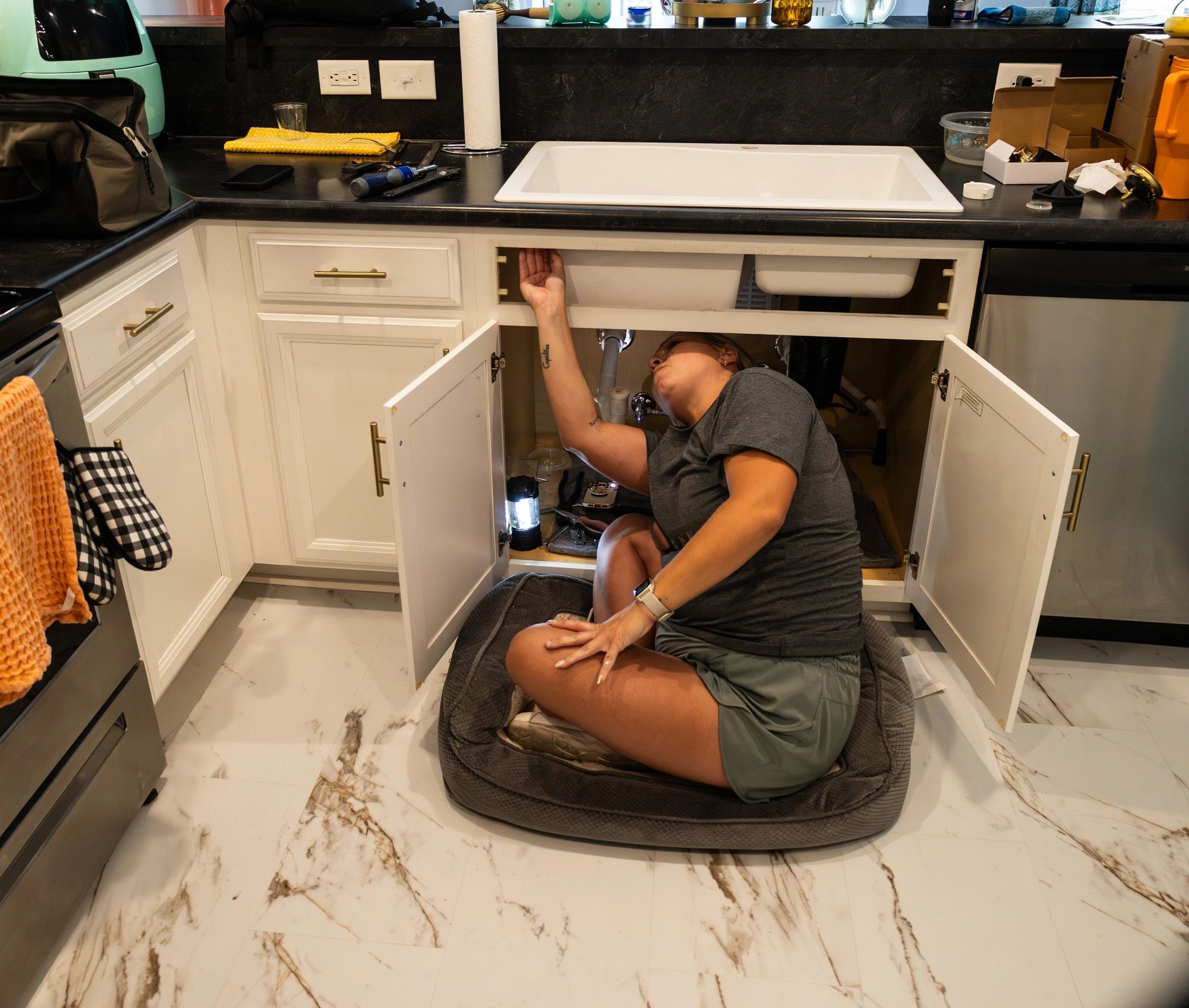 Technician working on kitchen sink plumbing